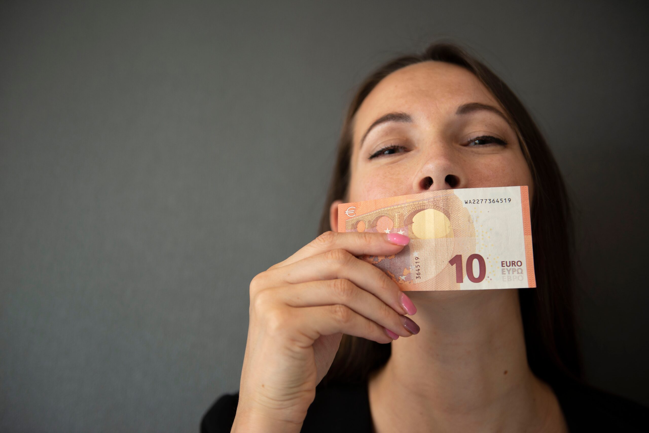 Frau küsst Geldschein